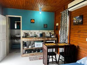 a kitchen with a counter and a table in a room at Casa Di Fiori in Apiúna