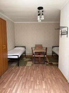a room with a table and a bed and a table and chairs at Yhome in Karakol
