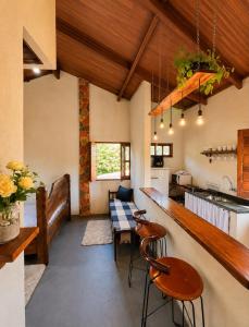 a kitchen with a counter and a table and chairs at Reserva do Bosque Hospedaria e Natureza in Ibicoara