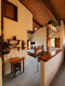 a living room with a table and a bedroom at Reserva do Bosque Hospedaria e Natureza in Ibicoara +39 photos