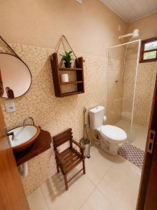 a bathroom with a toilet and a sink and a mirror at Reserva do Bosque Hospedaria e Natureza in Ibicoara