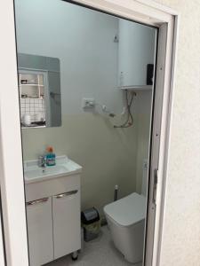 a bathroom with a toilet and a sink and a mirror at Yhome in Karakol