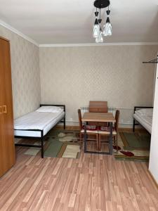 a room with two beds and a table and a bed at Yhome in Karakol +9 photos