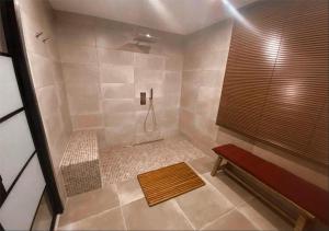 a bathroom with a shower with a bench in it at La perle rouge A Panazol in Panazol