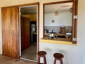 a kitchen with two stools and a mirror at Casa Monte Pacífico, jacuzzi, wifi Starlink y vista al mar in San Agustinillo