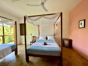 a bedroom with two beds and a canopy bed at Casa Monte Pacífico, jacuzzi, wifi Starlink y vista al mar in San Agustinillo