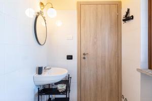 a bathroom with a sink and a wooden door at BB10 OASI in Arona