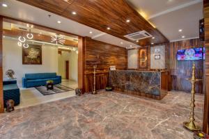 a lobby with a blue couch and a tv at Hotel Bhagyalaxmi NX in Shirdi