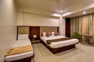 a hotel room with two beds and a table at Hotel Bhagyalaxmi NX in Shirdi +39 photos