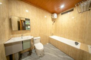 a bathroom with a toilet and a sink and a bath tub at Sunrise Cottage in Nusa Penida
