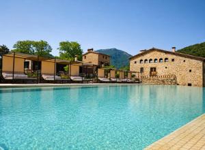 a large swimming pool in front of a building at Hotel Finca Llongarriu - Only Adults in Vall de Bianya