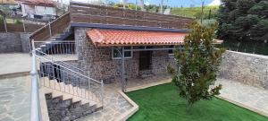 a house with a staircase and a green yard at Villa Sotiriou in Límni