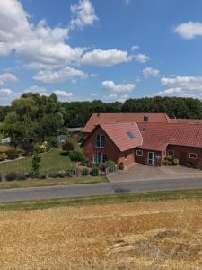 a house with a red roof and a road at Ferienhof Michaelis in Bruchhausen-Vilsen
