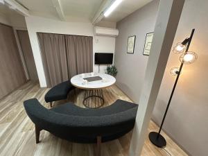 a living room with a table and a chair at koharubi hanada in Murochō