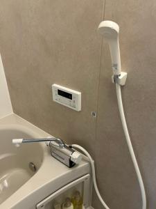 a shower in a bathroom with a toilet with a hose at koharubi hanada in Murochō +53 photos