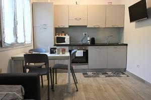 a kitchen with a table with chairs and a microwave at Casa Lissi in Bordighera
