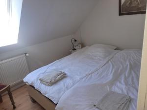 a white bed with two towels on top of it at Lejbølle gamle Bageri værelse 2 in Bøstrup