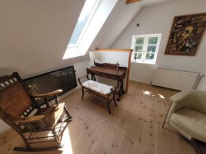 a living room with a piano and a chair at Lejbølle gamle Bageri værelse 2 in Bøstrup