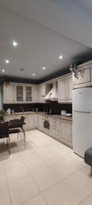 a kitchen with white cabinets and a table in it at Villa Sotiriou in Límni