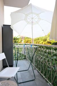a white umbrella sitting on top of a balcony at Casa Lissi in Bordighera