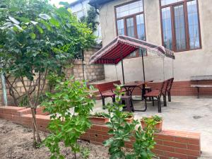 a patio with a table and chairs and awning at Halal House Vip in Qusar