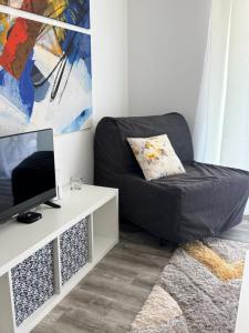 a living room with a black chair and a tv at Balchik Sea View Studio in Balchik