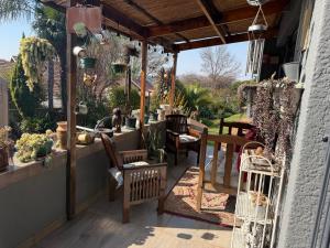 a patio with chairs and a table and some plants at Sweet Willa Bed and Breakfast in Roodepoort