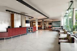 a lobby with couches and chairs in a building at Four Points by Sheraton Catania Hotel in Catania +129 photos