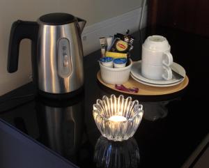 a coffee maker on a counter with a candle on a table at Vejby Strand Hotel in Vejbystrand