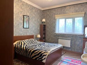a bedroom with a zebra print bed and a window at Halal House Vip in Qusar