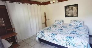 a bedroom with a bed with a blue comforter at SJO Green Casita in Santiago Este