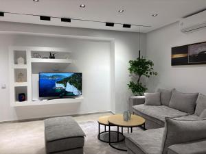 a living room with a couch and a tv at Luminoza Villa Zakynthos in Volímai