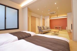 a hotel room with two beds and a chair at Dogo Onsen Yachiyo 道後温泉八千代 in Matsuyama +13 photos