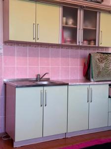 a kitchen with white cabinets and a sink at Ayara home in Kyzart