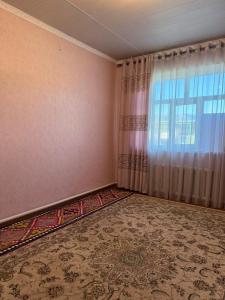 an empty room with a window and a rug at Ayara home in Kyzart