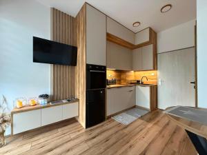 a kitchen with white cabinets and a black refrigerator at Apartmán 504 Svit in Jezersko