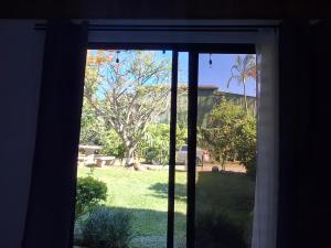 a view of a yard through a window at SJO Green Casita in Santiago Este