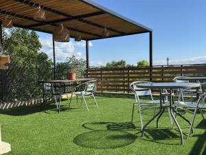 a patio with tables and chairs on the grass at Vivaldi Suites in Villa Carlos Paz