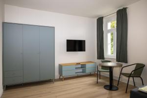 a living room with a table and a dresser and a tv at Ferienwohnung Brück in Bitterfeld