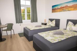 a bedroom with two beds and a table and a chair at Ferienwohnung Brück in Bitterfeld