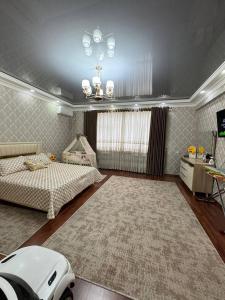 a bedroom with a bed and a table and a chandelier at Mamura Karimova in Andizhan