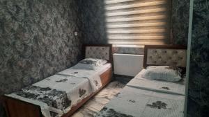 two twin beds in a room with a wall at Mamura Karimova in Andizhan