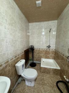 a bathroom with a toilet and a shower and a sink at Mamura Karimova in Andizhan