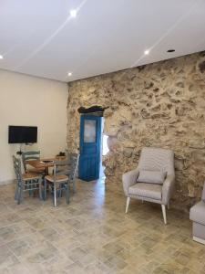 ein Raum mit einer Steinwand mit Stühlen und einem Tisch in der Unterkunft Bmehrine The Inn in Byblos