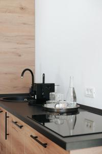 a kitchen counter with a sink and some dishes at Chalets by Hotel Transalpin in Obarsia-Lotrului