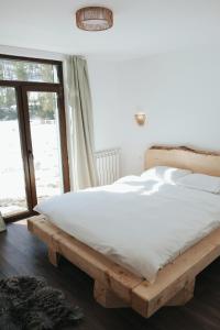 a bedroom with a wooden bed and a window at Chalets by Hotel Transalpin in Obarsia-Lotrului