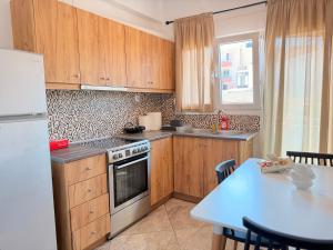 a kitchen with wooden cabinets and a white refrigerator at Central Park Chíos in Chios