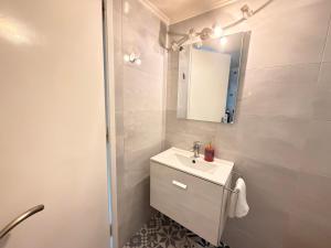 a white bathroom with a sink and a mirror at Central Park Chíos in Chios +6 photos