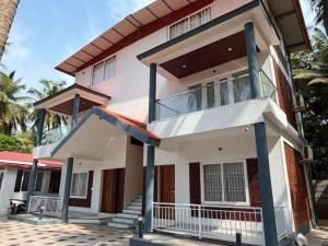 a house on the beach with palm trees at Seabreeze Village Resort and Restaurant in Gokarn
