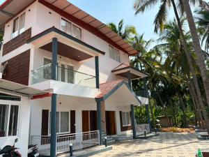 a house with palm trees in front of it at Seabreeze Village Resort and Restaurant in Gokarn